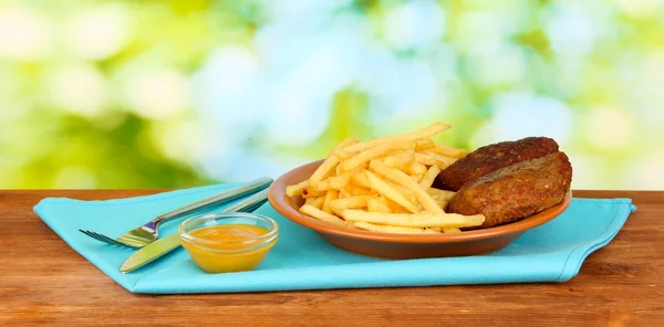 Aardappelen friet met hamburgers op de plaat op groene achtergrond close-up — Stockfoto