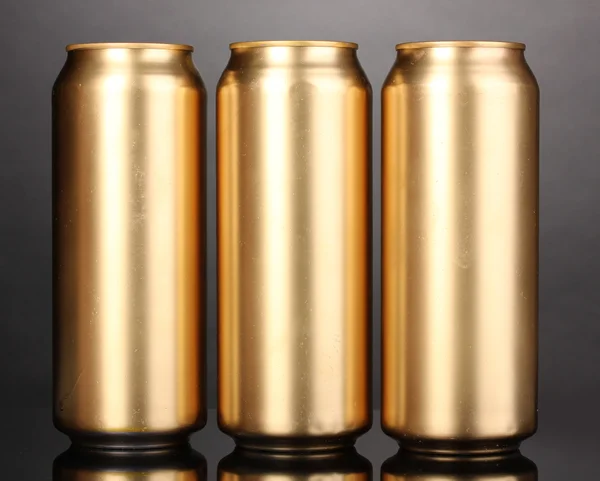 Golden cans on grey background — Stock Photo, Image