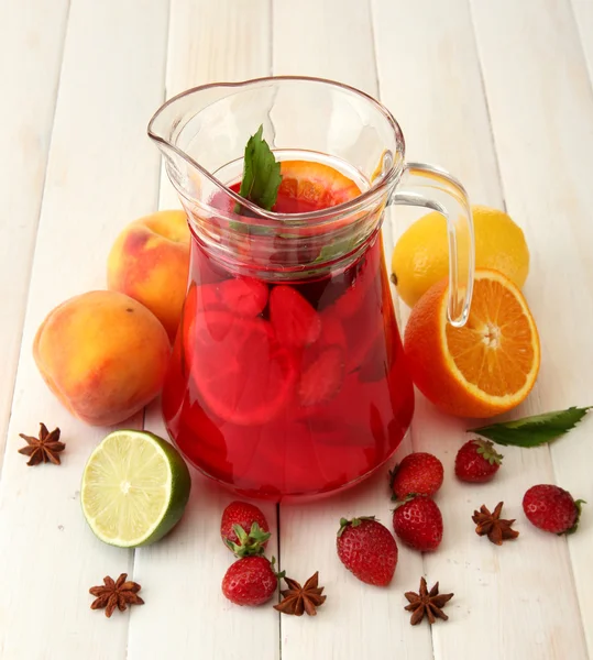 Sangria em jarra com frutas, sobre mesa de madeira branca — Fotografia de Stock