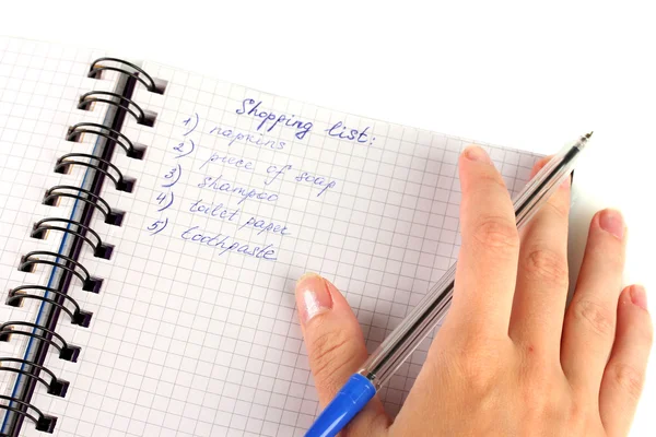 Mão da mulher segurando um caderno com uma lista de compras close-up — Fotografia de Stock