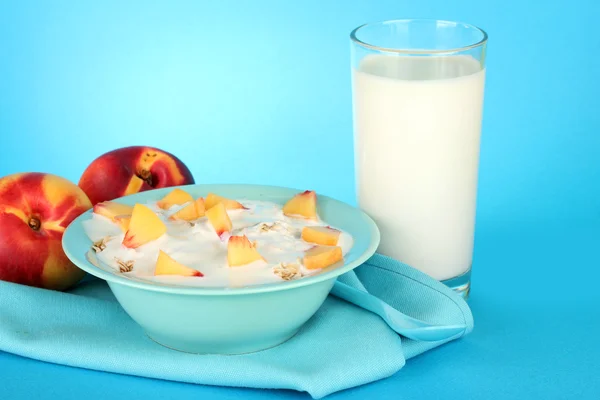 Sabrosos alimentos dietéticos y vaso de leche, sobre fondo azul —  Fotos de Stock