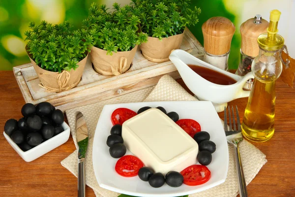 Feta cheese on plate decorated with spices and oil on wooden table on natur — Stock Photo, Image