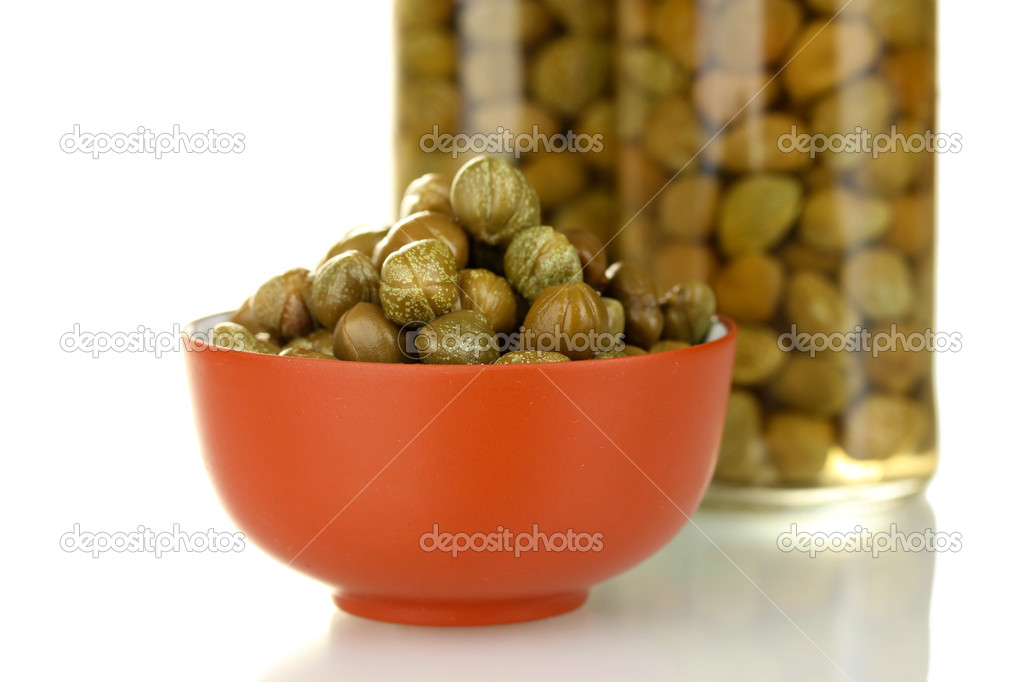 green capers in ceramical bowl on white background