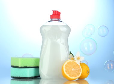 sünger ve çiçekli mavi zemin üzerine limon ile bulaşık deterjanı