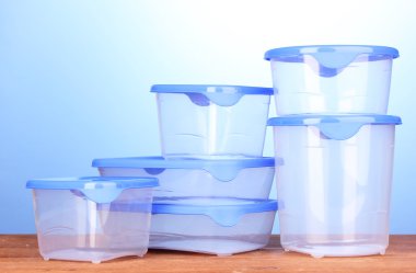 ahşap masa mavi zemin üzerine yemek plastik kaplar