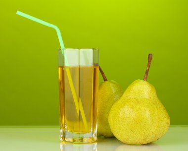 Pear juice in a glass on green background