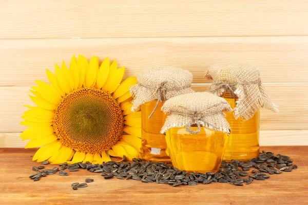 Sunflower oil and sunflower on wood background — Stock Photo, Image