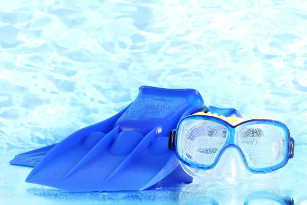 Blauwe flippers en masker op blauwe zee achtergrond — Stockfoto