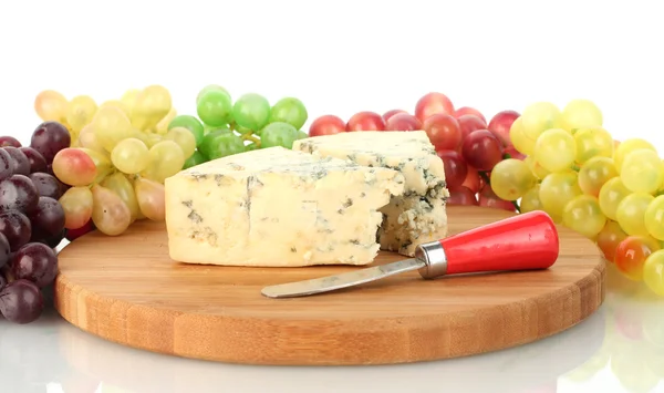 Queijo com molde na tábua de corte com uvas no fundo branco fechar — Fotografia de Stock