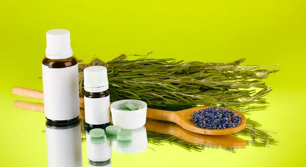 Garrafas de medicamentos e ervas no fundo verde. conceito de homeopatia — Fotografia de Stock