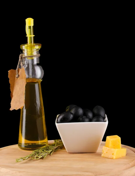 Olives noires dans un bol blanc avec romarin, huile d'olive et fromage à bord isol — Photo