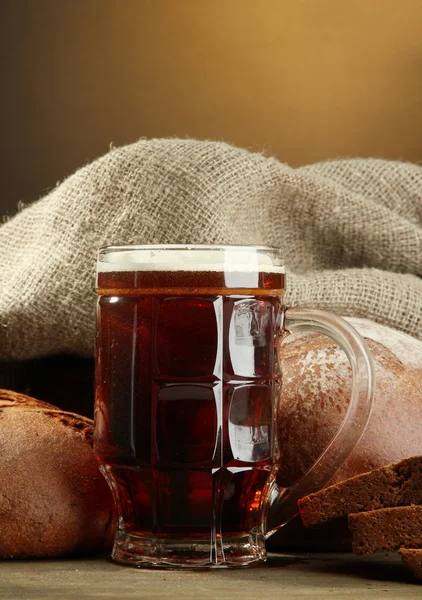 Tankard svagdricka och råg bröd, på träbord på brun bakgrund — Stockfoto