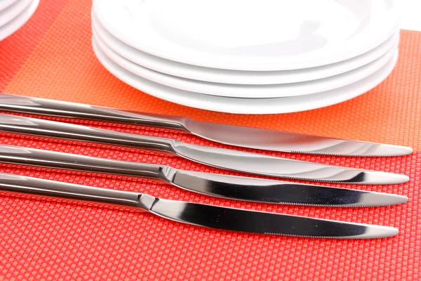 Vidličky, nože a lžíce na červené mat detail — Stock fotografie