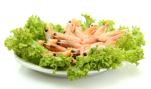 Crevettes bouillies avec feuilles de laitue sur plaque, isolées sur blanc — Photo