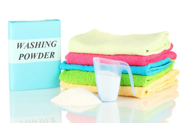 Box of washing powder with blue measuring cup and towels, isolated on white — Stock Photo, Image