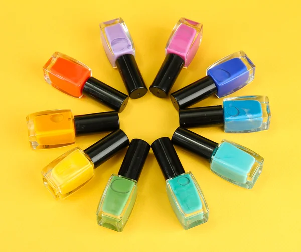 Grupo de esmaltes de uñas brillantes, sobre fondo amarillo — Foto de Stock