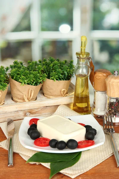 Feta-Käse auf Teller mit Gewürzen und Öl auf Holztisch auf windo dekoriert — Stockfoto