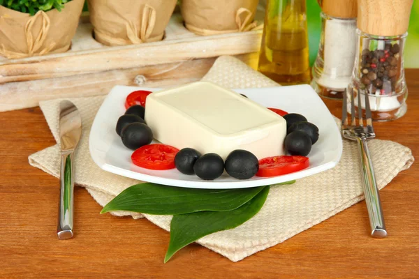 Fromage feta sur assiette décorée d'épices et huile sur table en bois sur natur — Photo