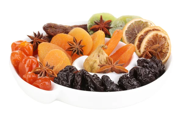 Сушеные фрукты с анисовыми звездами на пластине, изолированные на белом — стоковое фото