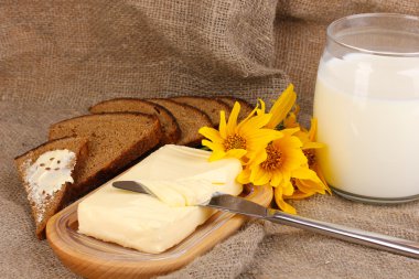 Ahşap kutusunda çevrili arka plan çuval bezi üzerinde süt ve ekmek tereyağı