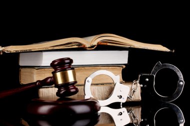 Gavel, handcuffs and books on law isolated on black close-up clipart