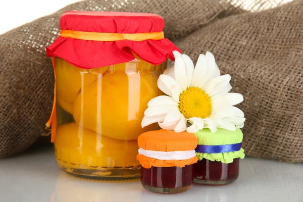 Vaso con frutta in scatola su sfondo tela primo piano — Foto Stock