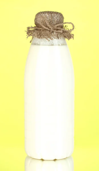 黄色の背景のクローズ アップにミルクのボトル — ストック写真