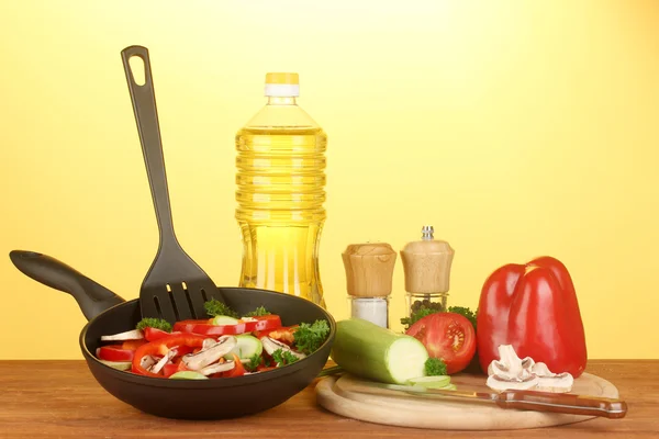 Sartén con verduras sobre fondo amarillo — Foto de Stock