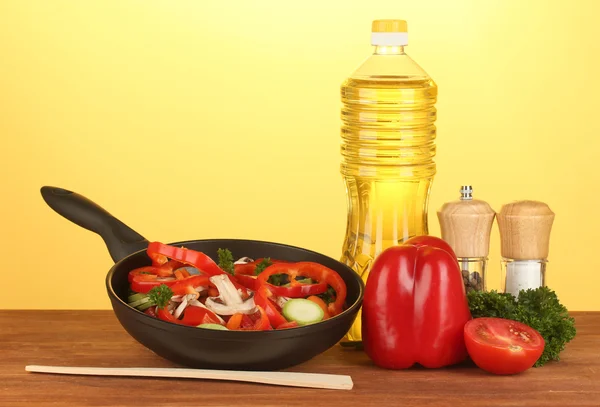 Frigideira com legumes no fundo amarelo — Fotografia de Stock