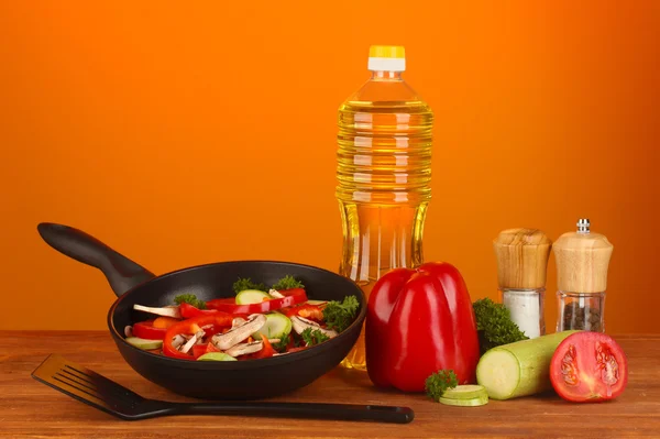 Сковородка с овощами на красном фоне — стоковое фото