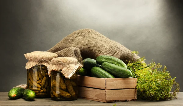 Färska gurkor i trälåda, pickles och dill, på grå bakgrund — Stockfoto