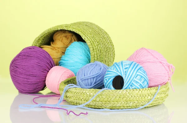 Colorful yarn for knitting in green basket on green background — Stock Photo, Image