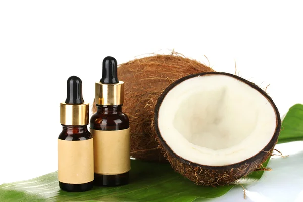 Aceite de coco en botellas con cocos sobre fondo blanco — Foto de Stock