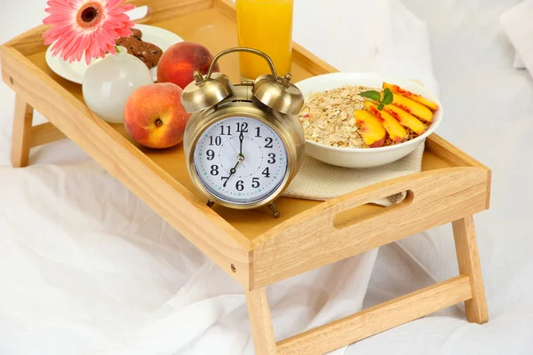 Träbricka med lätt frukost på sängen — Stockfoto