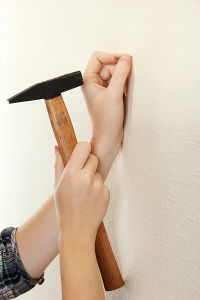 Vrouw handen met nagel en de hamer — Stockfoto