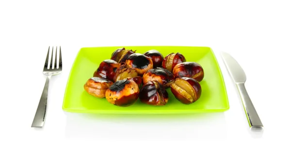 Roasted chestnuts in the green plate with fork and knife isolated on white — Stock Photo, Image