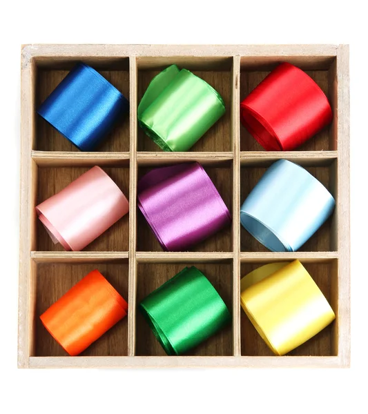 Světlé hedvábné stužky v dřevěné krabici, izolované na bílém — Stock fotografie