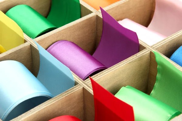 Bright silk ribbons in wooden box, close up — Stock Photo, Image
