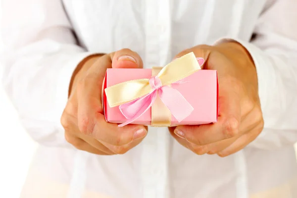 Woman holds a box with a gift on white background close-up — Stock Photo, Image