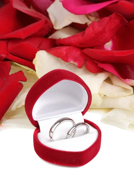 Mooie doos met bruiloft ringen op rode, witte en roze roze bloemblaadjes backgro — Stockfoto