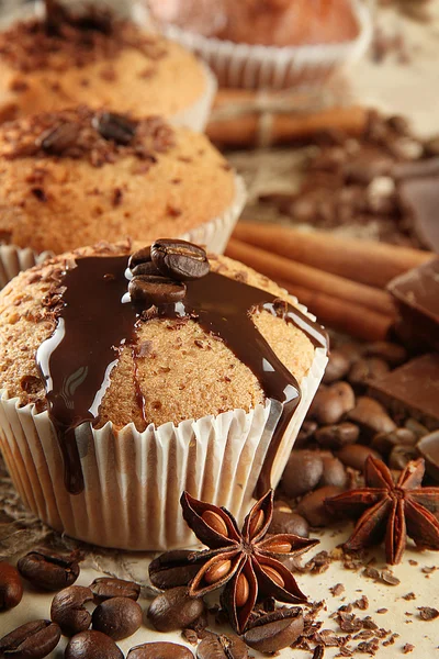 Tasty muffin cakes with chocolate, spices and coffee seeds, close up — Zdjęcie stockowe