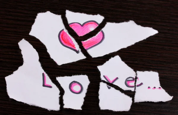 Gescheurd papier met woorden love close-up op houten tafel — Stockfoto