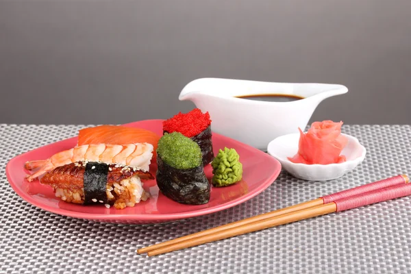 Plaka gri arka plan üzerine lezzetli sushi servis — Stok fotoğraf
