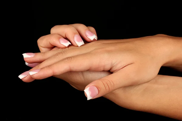 Mooie vrouw handen met Frans manicure op zwarte achtergrond — Stockfoto
