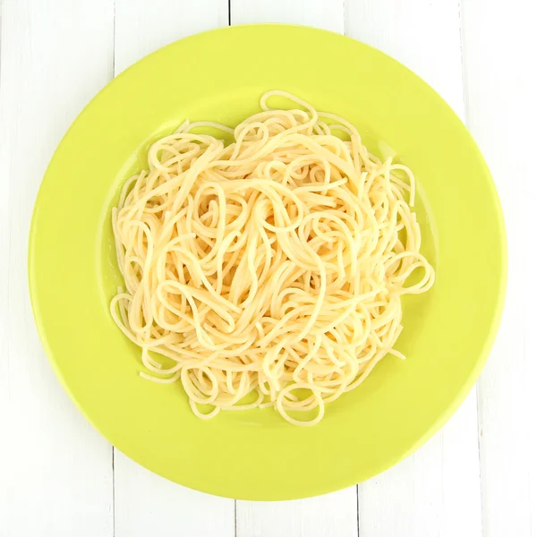 Spaghetti italiani in piatto su tavolo di legno — Foto Stock