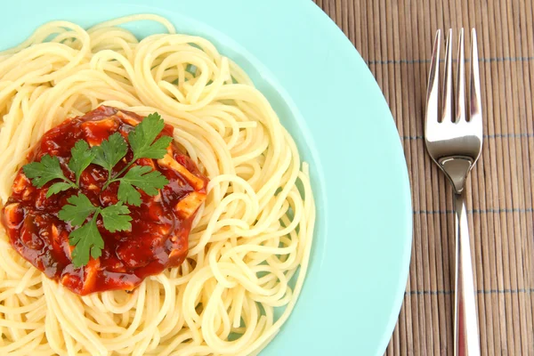 Italian spaghetti in plate on bamboo mat — Stock Photo, Image