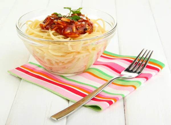 Italské špagety ve skleněné mísy na dřevěný stůl — Stock fotografie