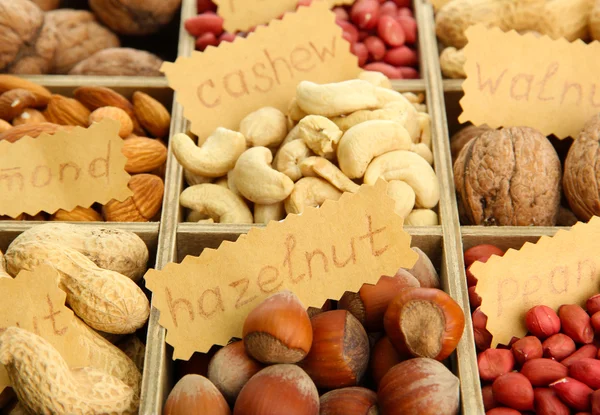 Assortment of tasty nuts in wooden box, close up — Stock Photo, Image