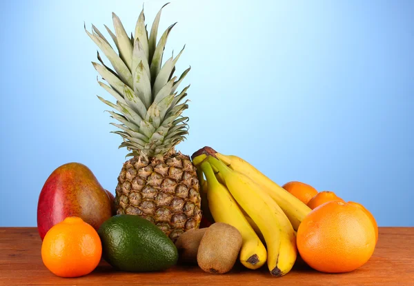 La naturaleza muerta de la fruta sobre la mesa sobre el fondo azul — Foto de Stock