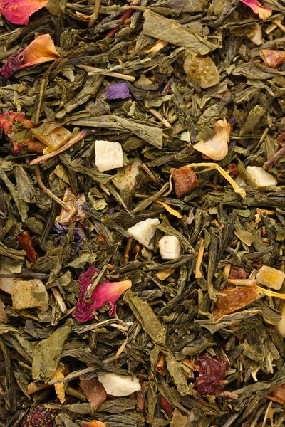 Aromatic green dry tea with fruits and petals, close up — Stock Photo, Image